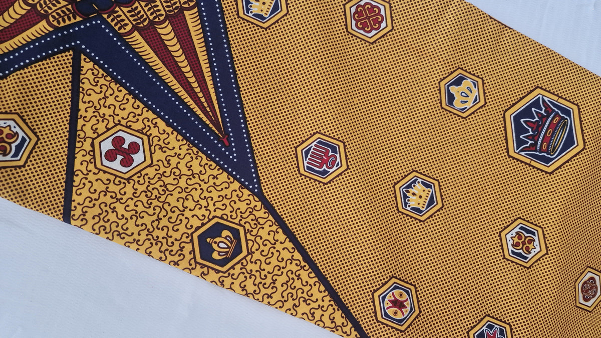 Patterned Ankara print featuring bold geometric and ornamental motifs in mustard yellow, white and dark brown