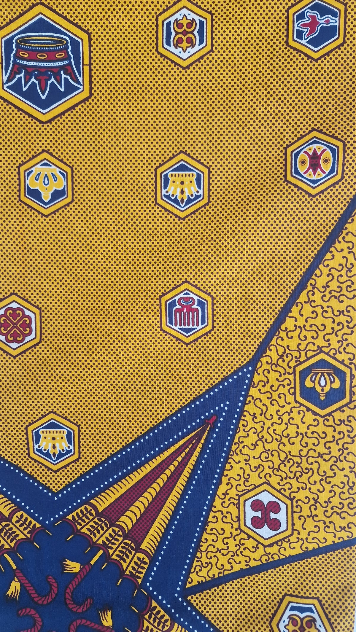 Patterned Ankara print featuring bold geometric and ornamental motifs in mustard yellow, white and dark brown