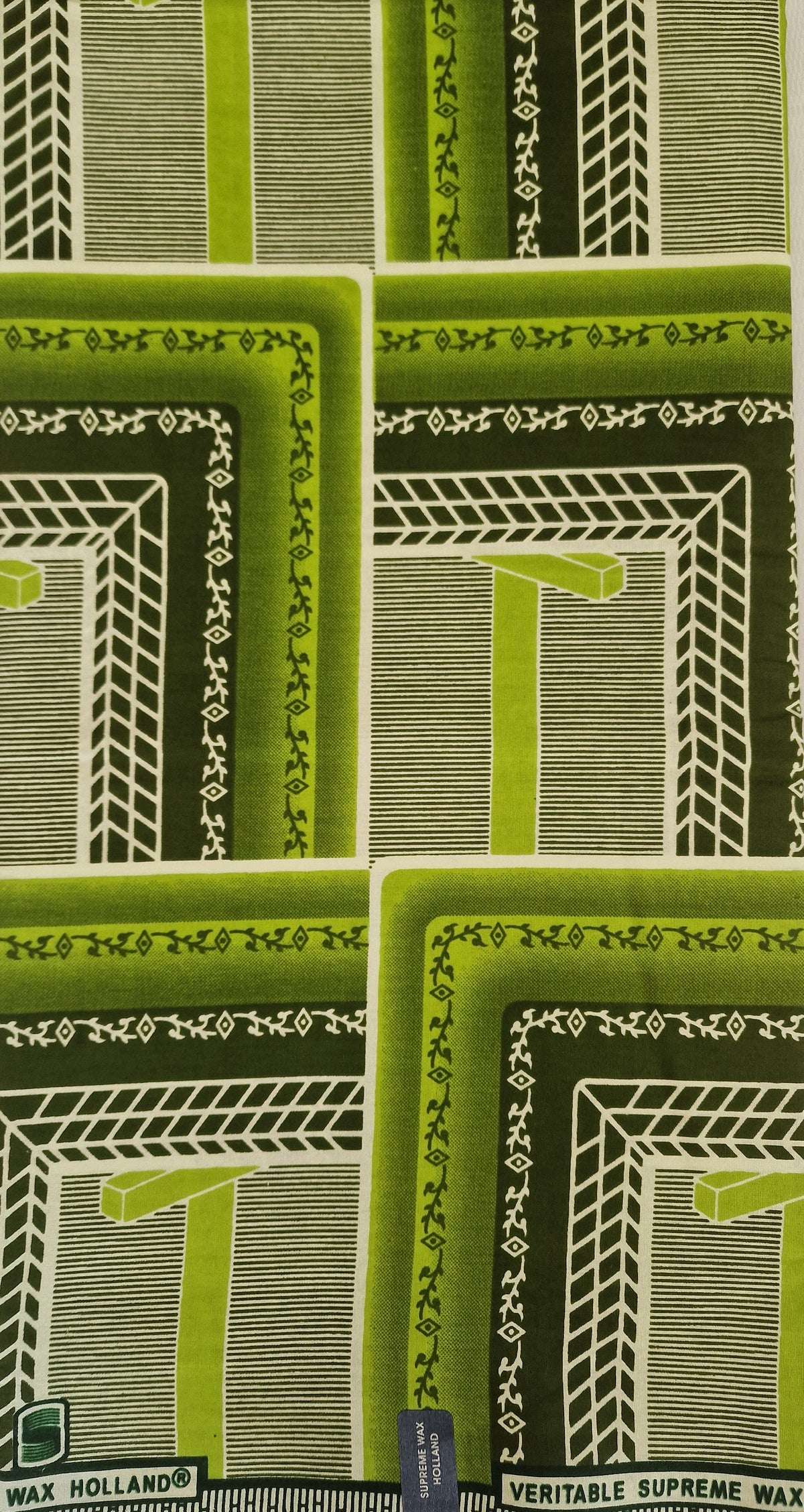 African Wax print featuring a retro geometric pattern in shades of green, olive, and white. The pattern consists of nested rectangular frames with striped and textured details