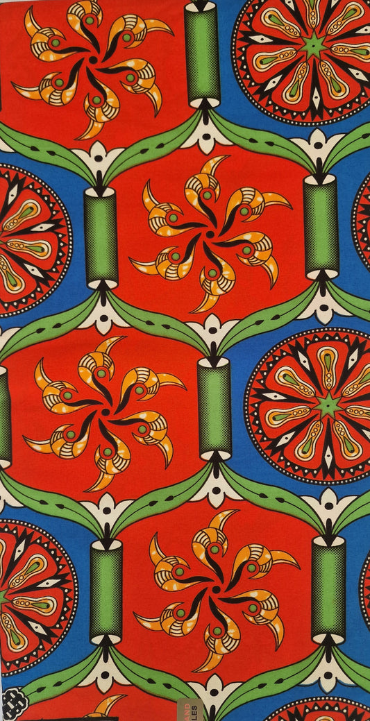 Traditional kola patterned African wax print fabric featuring vibrant red, blue, green, and yellow geometric designs and floral motifs.