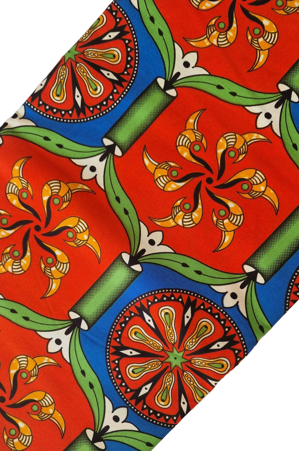 Traditional kola patterned African wax print fabric featuring vibrant red, blue, green, and yellow geometric designs and floral motifs.