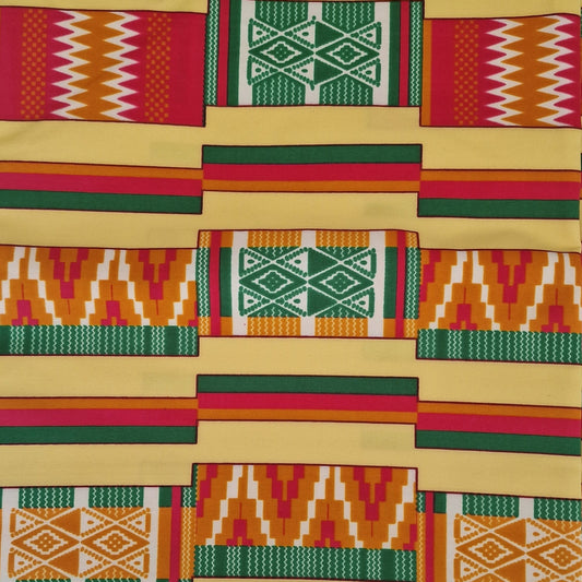 A folded piece of vibrant African wax print fabric with a geometric patchwork pattern in red, green, yellow, and white, displayed on a light background.