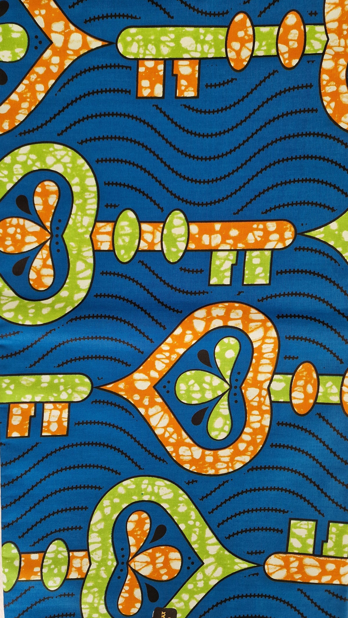 Premium Super wax patterned fabric with a bold blue background, orange and green abstract key-like motifs, and black wavy dotted lines. 