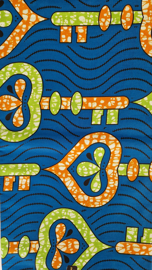 Premium Super wax patterned fabric with a bold blue background, orange and green abstract key-like motifs, and black wavy dotted lines. 